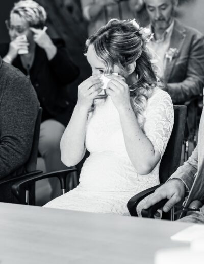 Emotionale Braut wischt sich Tränen während der Trauung – Helene Karsten Hochzeitsfotografie zeigt, wie bewegend Liebe sein kann.