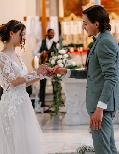 Mit einem Lächeln steckt die Braut dem Bräutigam den Ring an – natürliche Hochzeitsfotografie, die leise Geschichten erzählt.